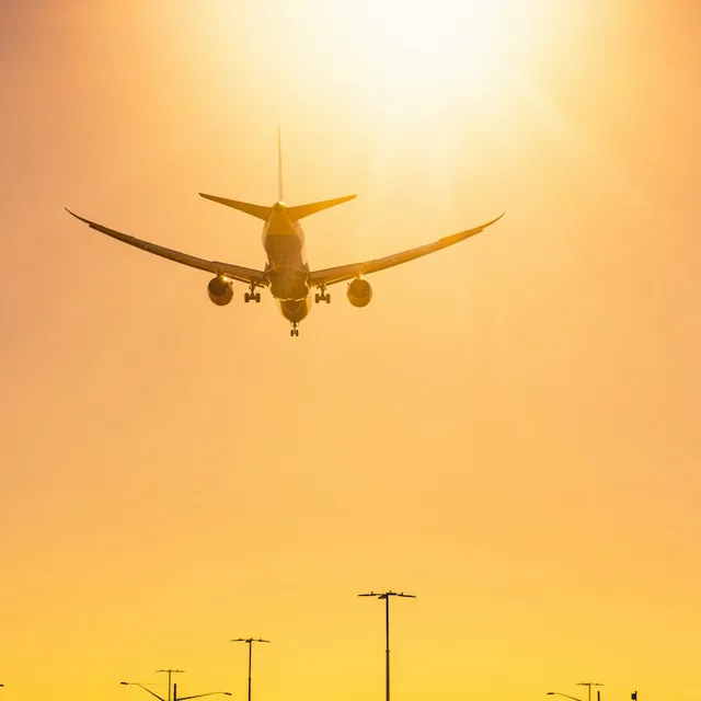 A plane landing at sunset