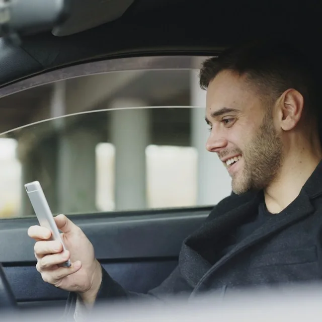 Smiling driver checking his ProPark booking on his phone in the car park